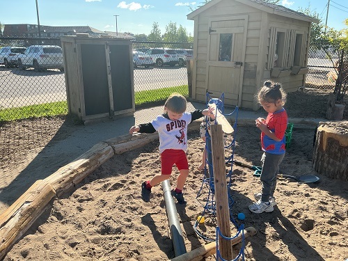 Preschool friends exploring the natural playground materials