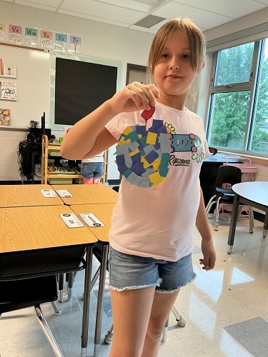 School age girl holding up her creation