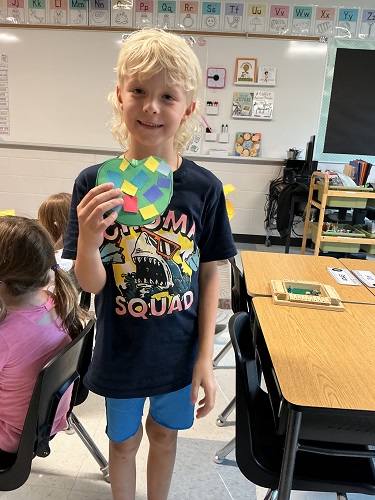 Child holding up their art creation
