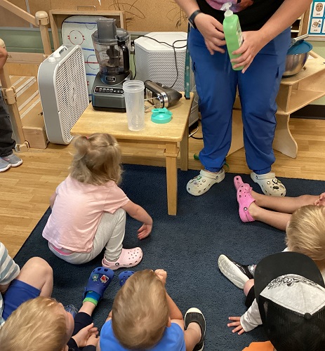 An educator showing the children how they are going to make bubbles