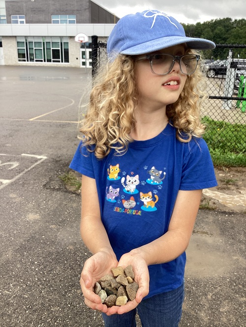 A school age child holding rocks