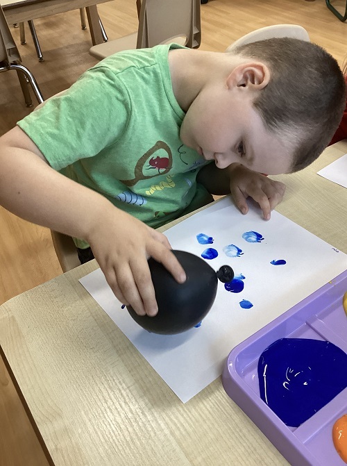 A preschool child making balloon art