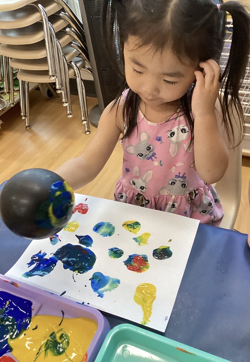 A preschool child making balloon art