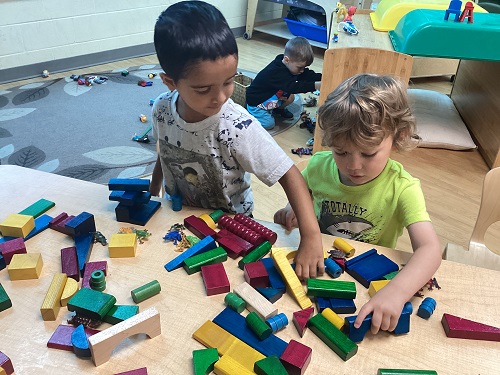 Two preschool children engaged in block play