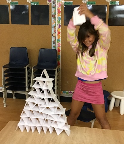 child with a card tower