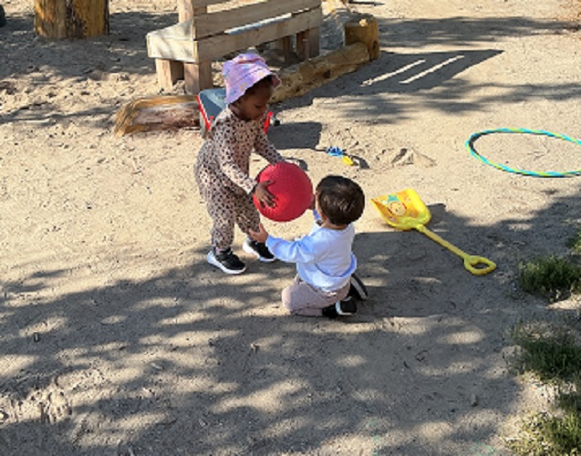 A child passing a ball to another child