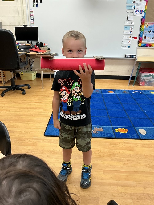a child holding up their airplane to the camera