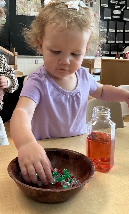a child seen picking up materials and placing them inside a bottle