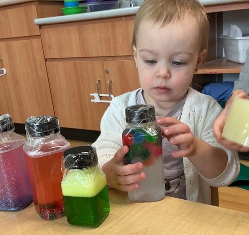 a child seen observing a sensory bottle in her hand