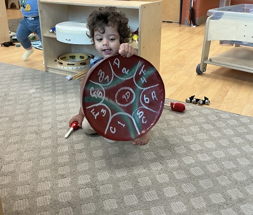Infant child exploring with drums